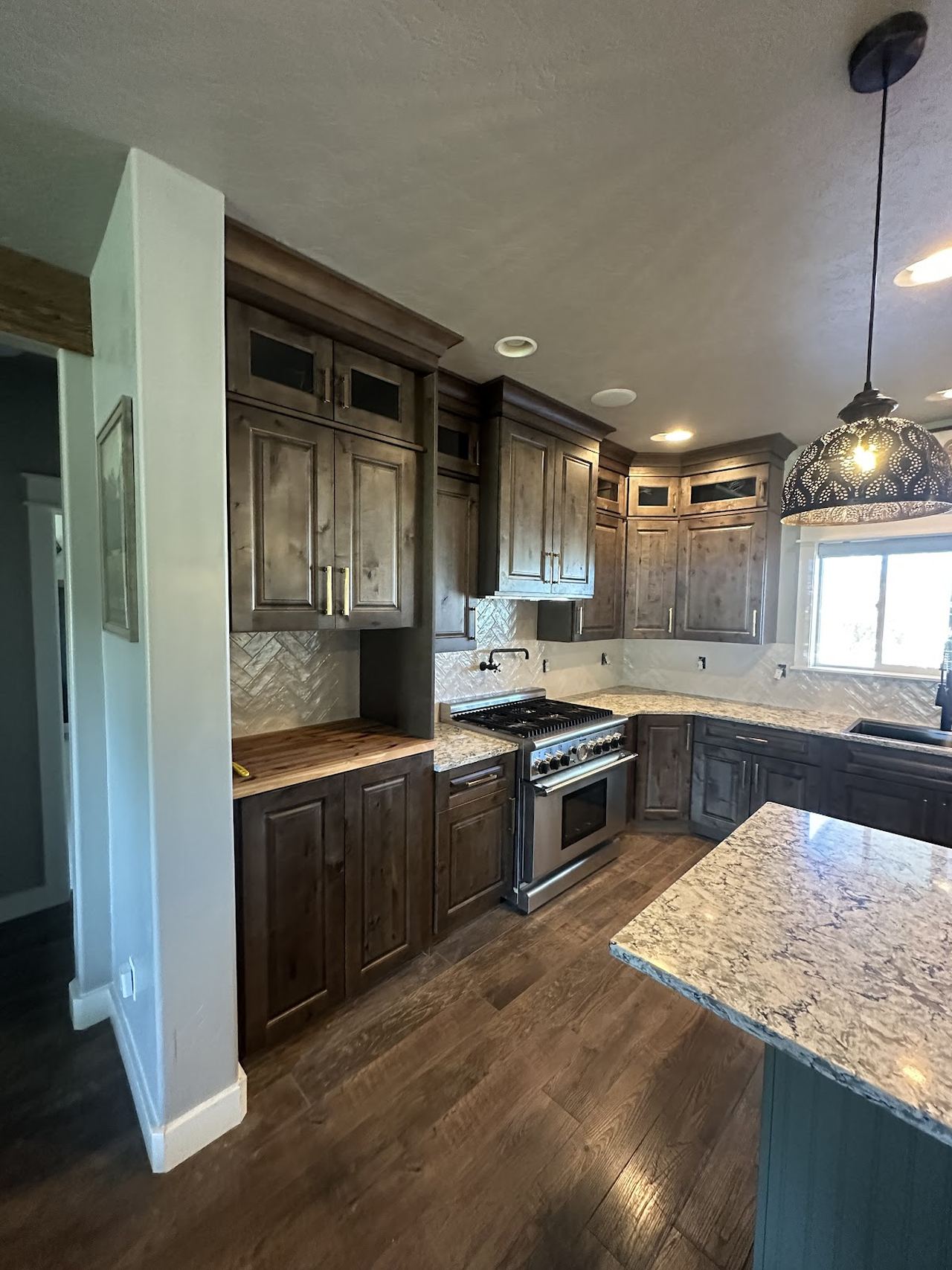 Finished kitchen remodel by Kovo's Karpentry — knotty alder cabinets, granite, herringbone tile